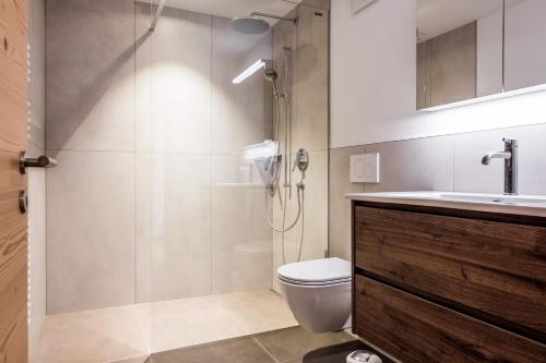 a bathroom with a shower and a toilet and a sink at Apartment Walt 3.5 - GRIWA RENT AG in Grindelwald
