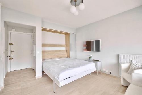 - une chambre blanche avec un lit et un canapé dans l'établissement Superbe studio avec terrasse à 10 min de la plage, à Cannes