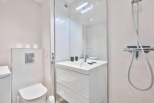 une salle de bain blanche avec douche et toilettes dans l'établissement Superbe studio avec terrasse à 10 min de la plage, à Cannes