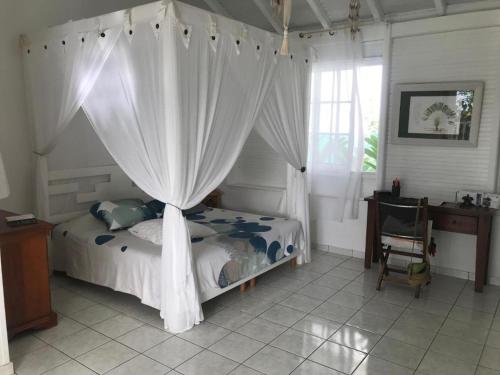 um quarto com uma cama de dossel em Superbe Villa de vacances aux Trois ilets em Les Trois-Îlets