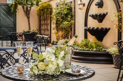 a table with a bottle of champagne and flowers on it at French Quarter Inn in Charleston