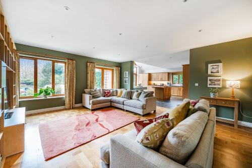 a living room with two couches and a kitchen at Treetops in Wimborne Minster