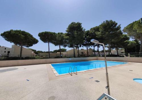 une piscine vide avec des arbres en arrière-plan dans l'établissement Appartement Cap d'Agde 2 Pièces et Mezzanine, au Cap d'Agde