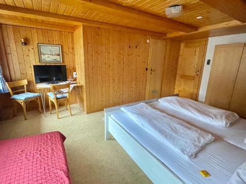 a bedroom with a bed and a desk and a television at Gasthaus Krone Holzschlag in Bonndorf im Schwarzwald