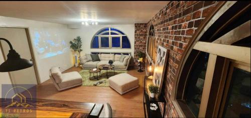 a living room with a couch and a brick wall at 2 Bedroom Penthouse at Suntrust Capitol Plaza, Diliman, Quezon City in Manila