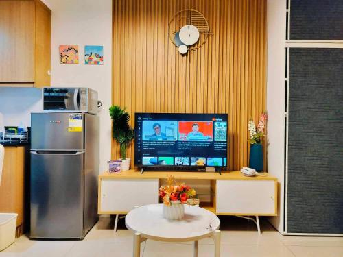 a kitchen with a refrigerator and a table with a tv at Shell Residences by Amonbrey Suite nr airport in Manila