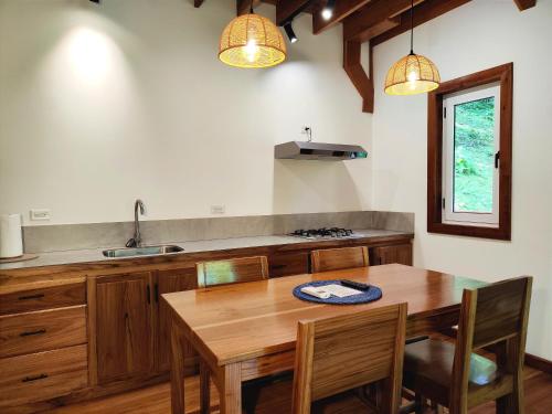 a kitchen with a wooden table and a sink at Gaia Nature Lodges at Bluff Beach in Bocas del Toro