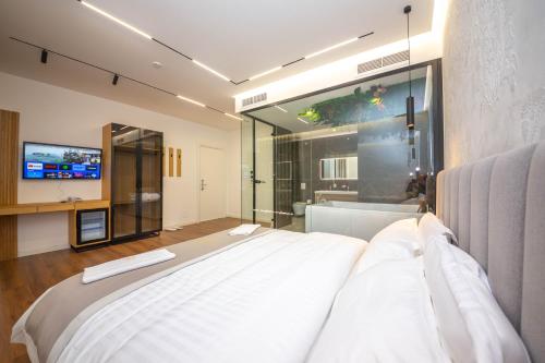 una camera con un grande letto e una televisione di Hotel Riviera a Tirana