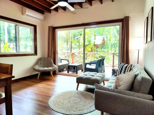 a living room with a couch and chairs and a large window at Gaia Nature Lodges at Bluff Beach in Bocas del Toro