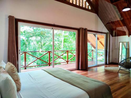 ein Schlafzimmer mit einem Bett und einem großen Fenster in der Unterkunft Gaia Nature Lodges at Bluff Beach in Bocas del Toro