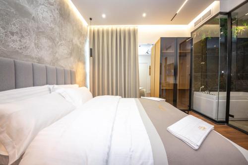 a bedroom with a white bed and a bath tub at Hotel Riviera in Tirana