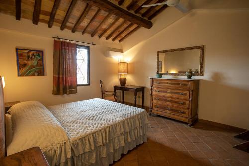a bedroom with a bed and a dresser and a mirror at Casale Esclusivo con Piscina e Vista su San Gimignano in San Gimignano