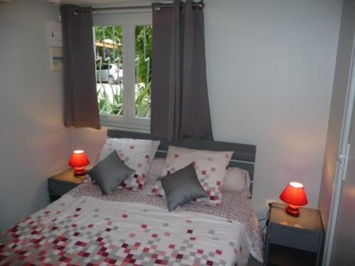 1 dormitorio con cama con almohadas y ventana en Appartement d'une chambre avec jacuzzi terrasse et wifi a Latresne, en Latresne