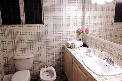 a white bathroom with a toilet and a sink at Casa Piscina - House with a pool in David in David