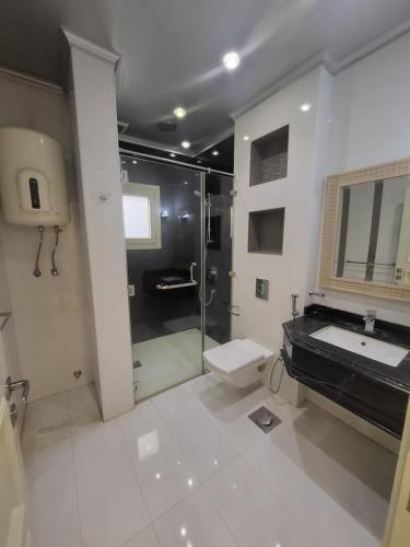 uma casa de banho com um chuveiro, um WC e um lavatório. em شقه فندقيه بالدقي no Cairo