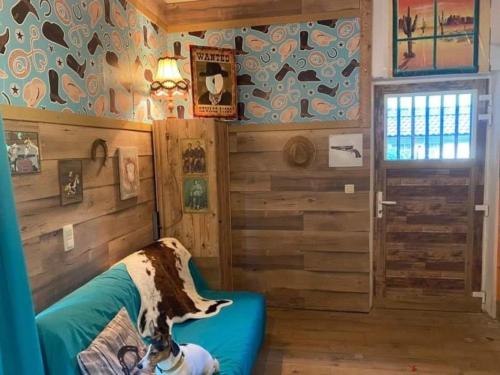 un perro sentado en un sofá en una habitación con paredes de madera en One bedroom apartement with terrace and wifi at Walcourt, en Walcourt