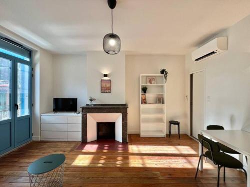 - un salon avec une cheminée, une table et des chaises dans l'établissement Beau Studio rue du Printemps, à Toulouse