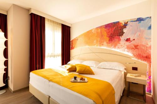 pokój hotelowy z łóżkiem i mapą na ścianie w obiekcie Color Hotel Style, Design & Gourmet w mieście Bardolino