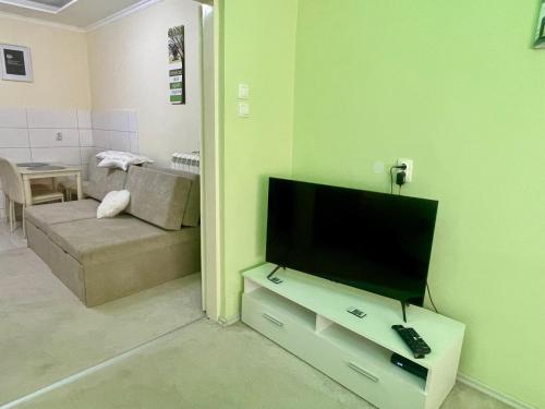 a living room with a flat screen tv on a stand at Belien Apartman in Makó