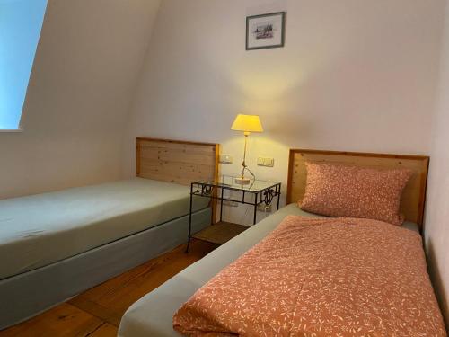 a small bedroom with a bed and a lamp at Hotel Weinstube am Markt in Gerolzhofen