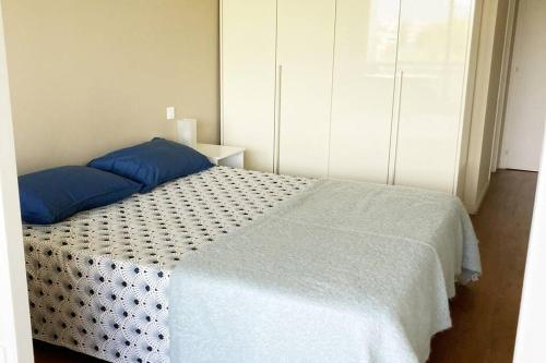 une chambre avec un lit avec des oreillers bleus dessus dans l'établissement appartement terrasse Nice , chambre , La piscine, à Nice