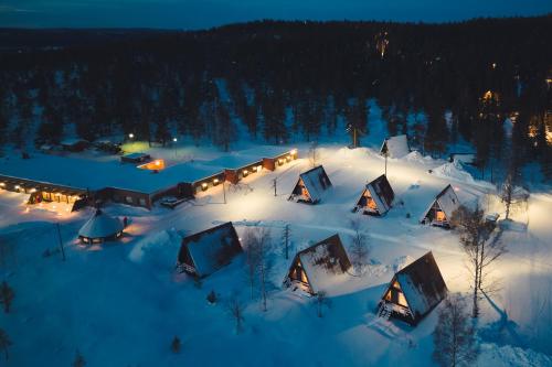 a group of lodges in the snow at night at Karemajat superb cottage in Ylitornio
