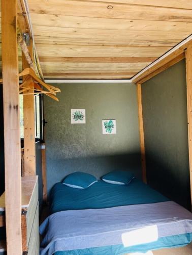 Bett in einem Zimmer mit Holzdecke in der Unterkunft Cabane in Olivese