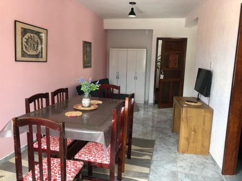 comedor con mesa, sillas y TV en Tamboleiros Hotel & Hostel, en Salvador