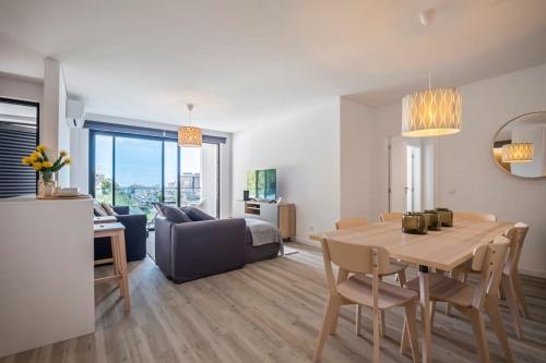 a dining room and living room with a table and a couch at CENTRAL LOCATION - WITH POOL in Funchal