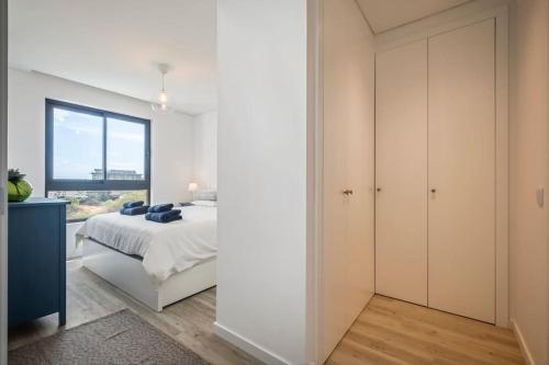 a white bedroom with a bed and a window at CENTRAL LOCATION - WITH POOL in Funchal