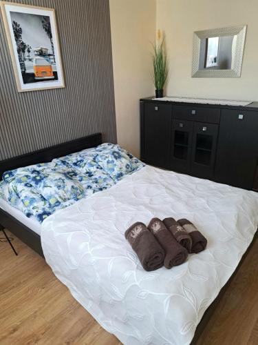 a bedroom with a bed with two slippers on it at Słoneczny - Mala Apartamenty in Wejherowo