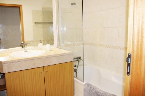 a bathroom with a sink and a shower and a tub at Apartment with terrace Albufeira Olhos de Água in Albufeira