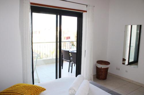 a bedroom with a bed and a view of a balcony at Apartment with terrace Albufeira Olhos de Água in Albufeira