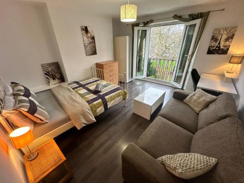 Renovu Exclusive Rooms London في لندن: غرفة معيشة مع أريكة وسرير
