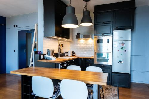 - une cuisine avec une table en bois et des chaises blanches dans l'établissement HappyFew Promenade Carras, à Nice