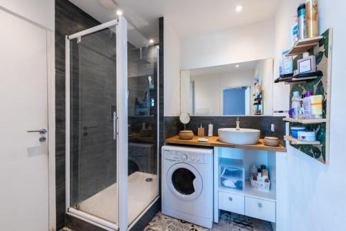 une salle de bain avec une machine à laver et un lavabo dans l'établissement HappyFew Promenade Carras, à Nice