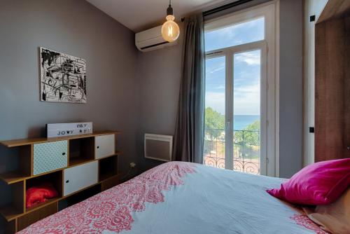 une chambre avec un lit et une grande fenêtre dans l'établissement HappyFew Promenade Carras, à Nice