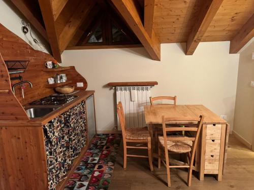 a kitchen with a wooden table and a table and chairs at Il Piccolo Sogno in Temù