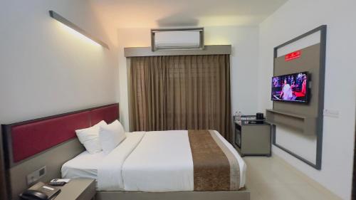 a hotel room with a bed and a tv at Spring Hill Hotel & Apartments in Dhaka