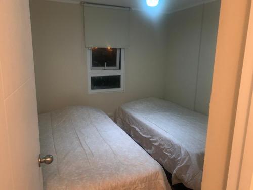 2 camas en una habitación pequeña con ventana en Alto mar II, en Viña del Mar