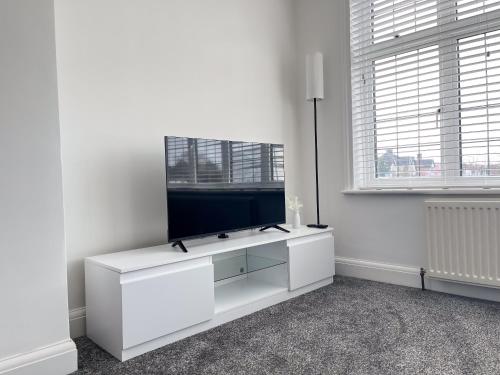a white living room with a flat screen tv at Wembley Stadium Central Modern & Cozy Apartment in London