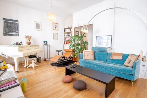 un salon avec un canapé bleu et un piano dans l'établissement Les Nocturnes de Chopin, à Tours