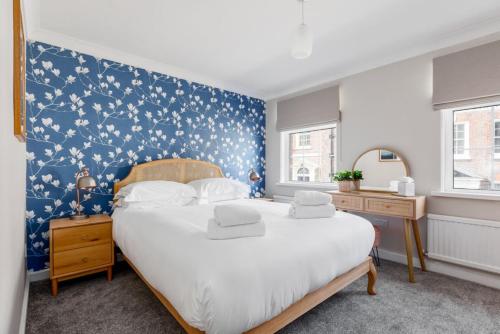 een slaapkamer met een groot bed met een blauwe muur bij Edward Cottage in Poole