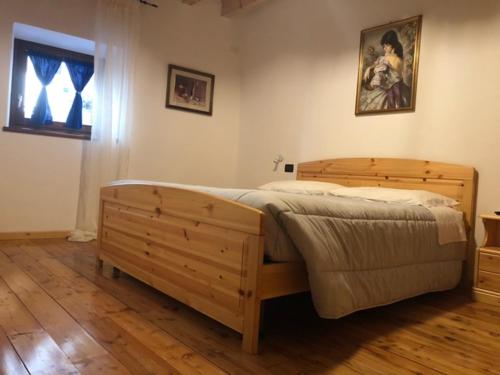 a bedroom with a wooden bed in a room at Antica Osteria Pace in Moerna