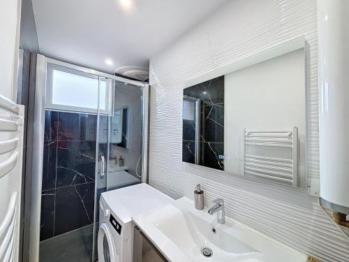 une salle de bain blanche avec un lavabo et une douche dans l'établissement Le Balcon - Vue sur canal de Brienne, à Toulouse