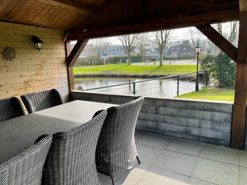 a patio with a table and chairs and a view of the water at B&B Tina in Sneek