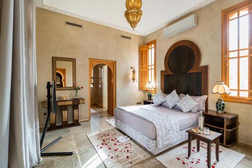 a bedroom with a large bed and a mirror at Palais Alcazar in Marrakech