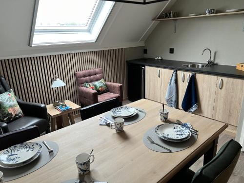 a living room with a table and a kitchen at B&B Tina in Sneek