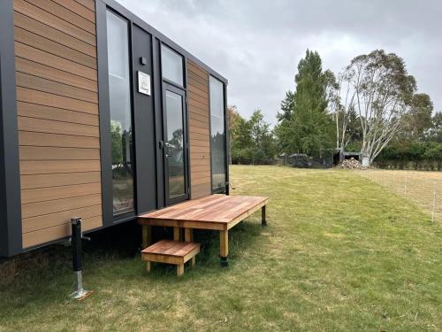 a bench sitting outside of a tiny house at Mona Vale Country Estate in Hawarden