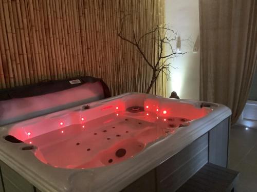 El baño incluye bañera roja con luces rojas. en Le carpe noctem, en Sérignan-du-Comtat